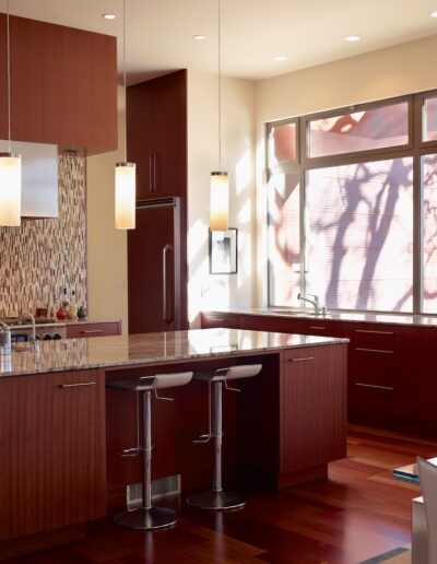 Modern kitchen interior with a central island and pendant lights.