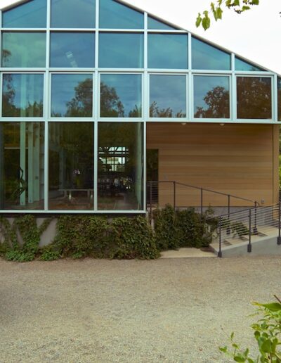 Modern glass building with a camouflage-clad figure standing in front.