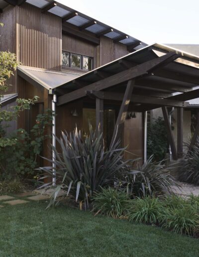 A modern house with a landscaped garden featuring succulents and a stepping stone path.