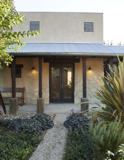 Modern single-story house with a flat roof, large windows, and a landscaped garden.