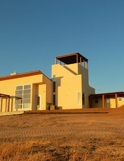 Modern house on a barren hillside at sunset.