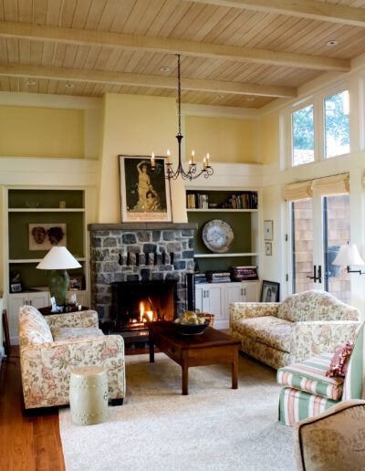 Elegant living room with a fireplace, patterned sofas, and a chandelier.